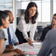 Team of multiethnic architects working on construction plans in meeting room. Engineers and designers discussing project in office. Businesswoman with business team in conference room working on blueprint.