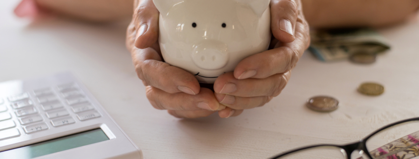 a person holding a piggy bank next to a calculator
